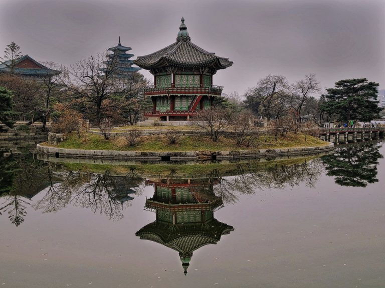 green and brown pagoda temple near lake